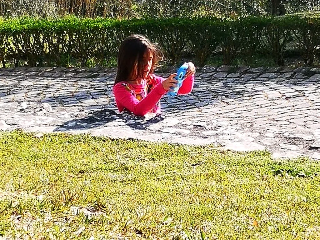 石畳の道で、上半身だけが見えている女の子の写真