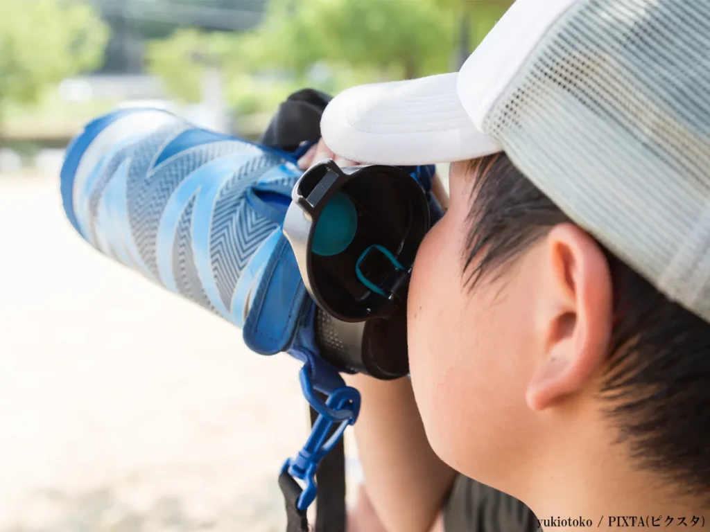 水筒で水分補給をする子供の画像