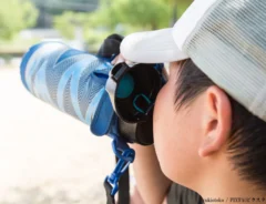 水筒で水分補給をする子供の画像