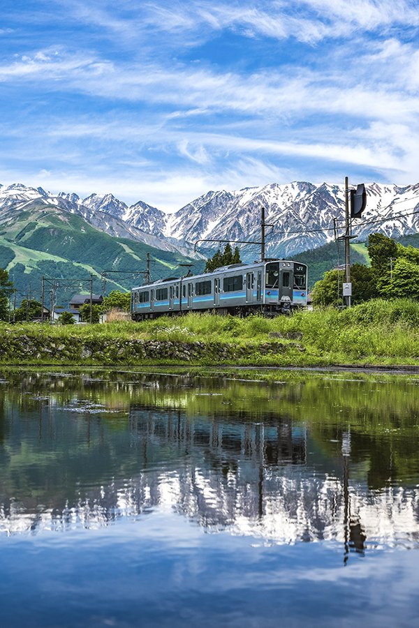 雪の残る山脈と電車の写真
