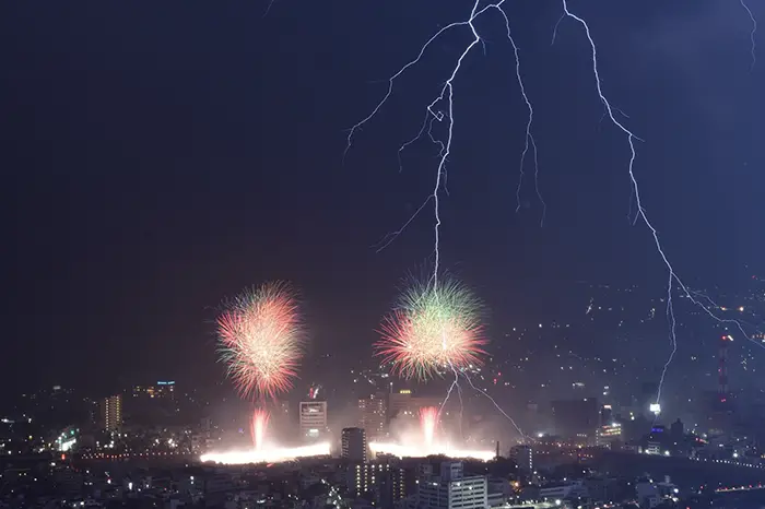 打ち上げ花火と雷の写真