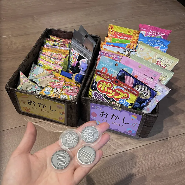 お菓子と手作りの100円玉が写る画像