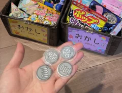 箱に入ったお菓子と手作りの100円玉の画像