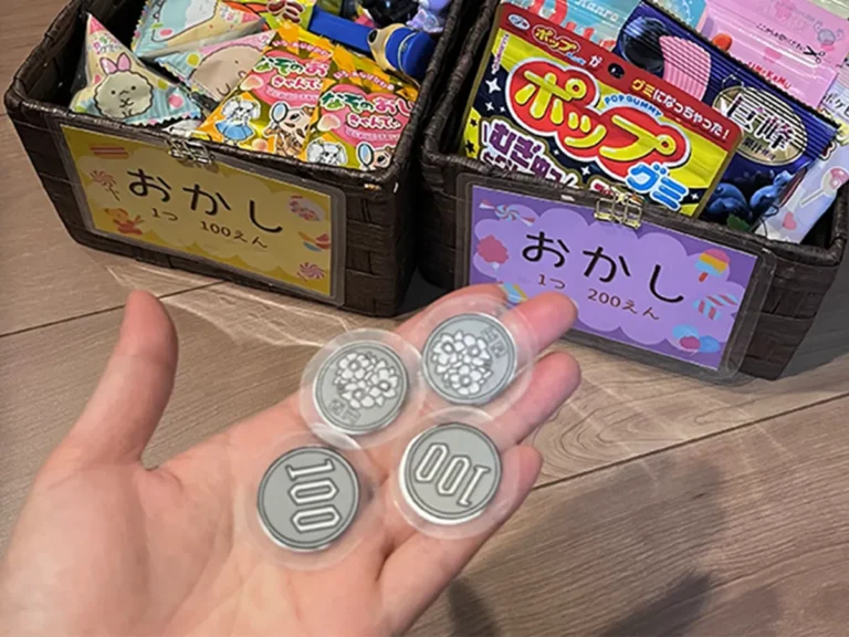 箱に入ったお菓子と手作りの100円玉の画像