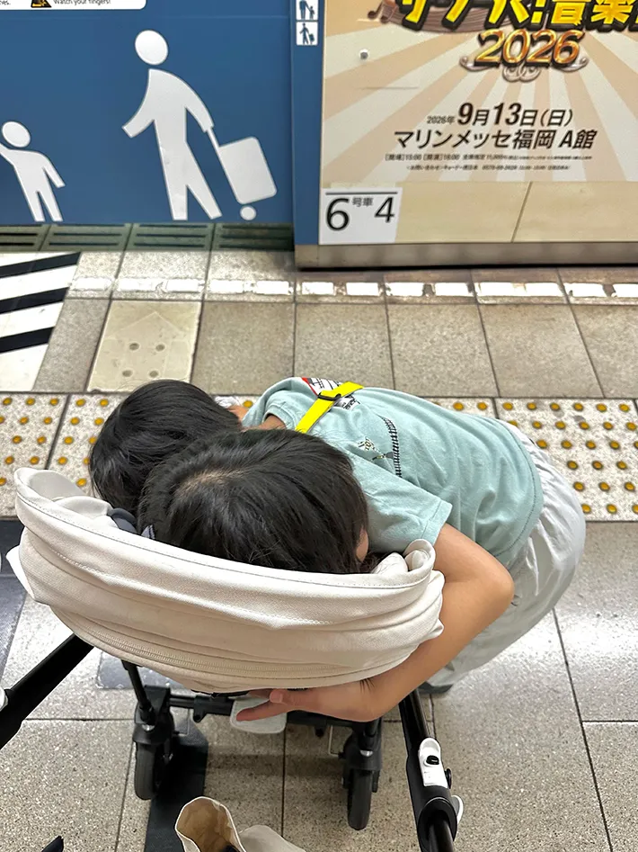 ベビーカーごと妹を抱きしめる小学1年生の男の子の画像