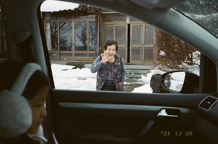 孫たちを見送る祖母の写真