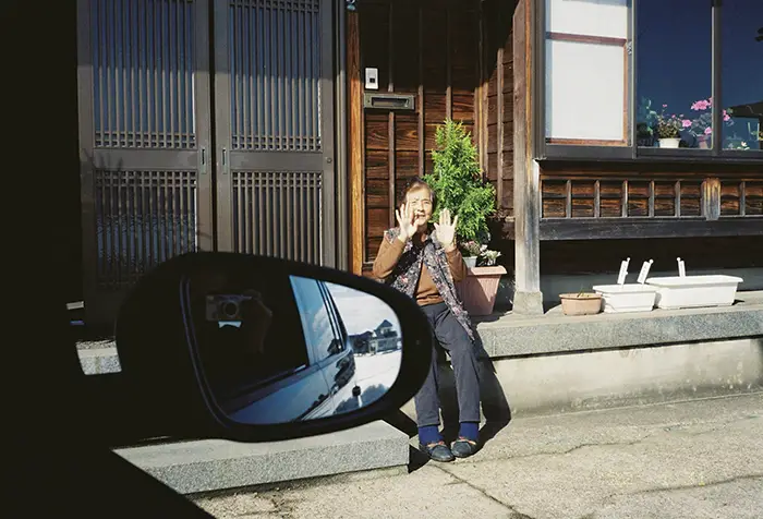 孫たちを見送る祖母の写真