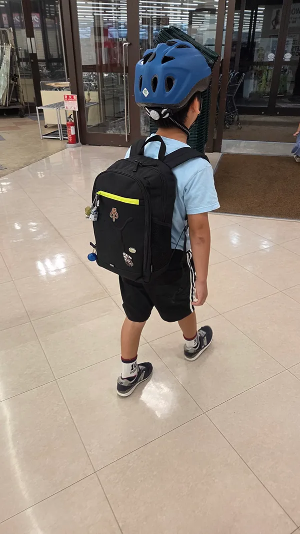 プレゼントをリュックにパンパンに詰めて歩く小2息子の画像