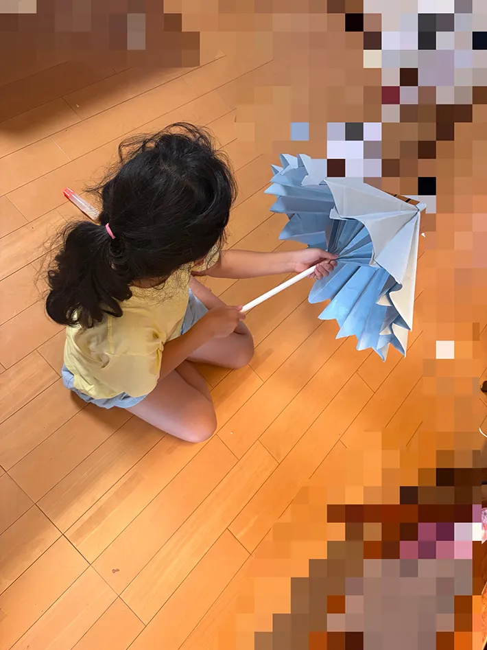 紙で作った傘の開閉を確認している写真
